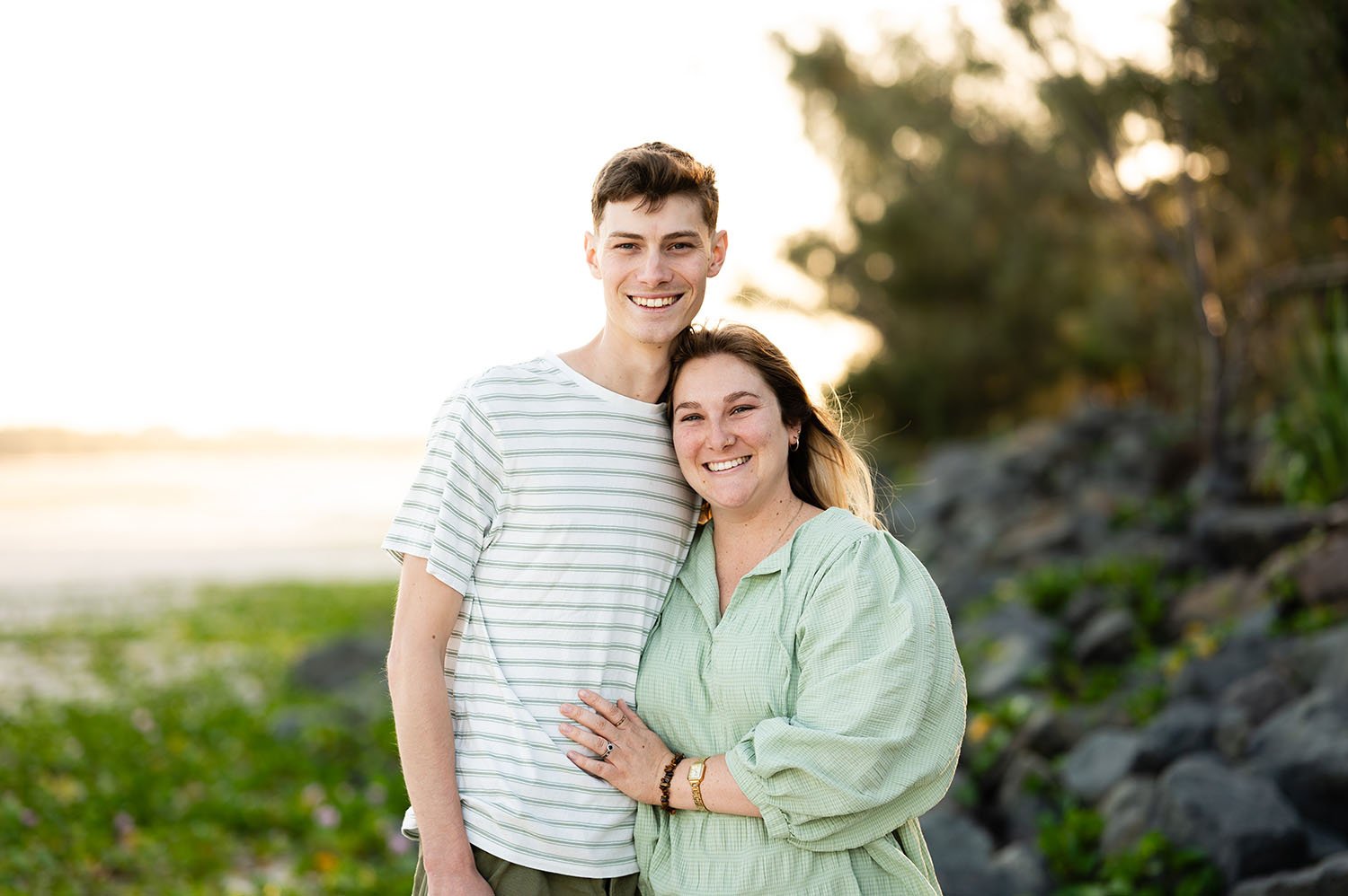 A couple smiling together in the golden light at the beach